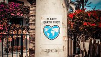 Plakat mit Beschriftung Planet Earth First hängt an einem Mast