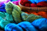 Tie of colorful and shiny beautiful silk yarn dyed placed in a pile of round bamboo basket